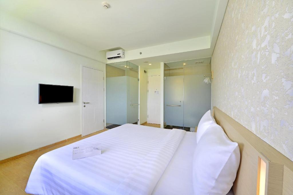 Letto o letti in una camera di Whiz Prime Hotel Sudirman Cilacap