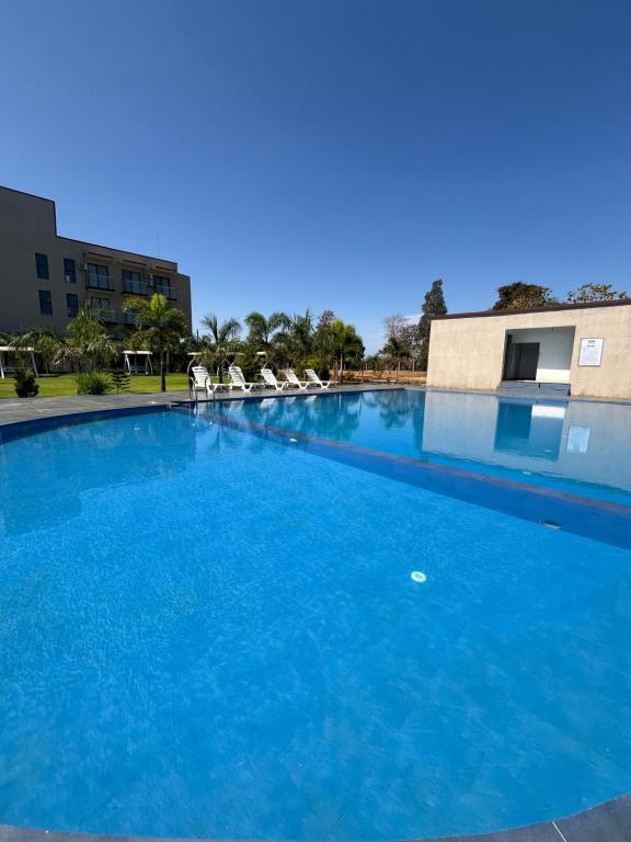 a large pool with blue water in a building at Daksh The Valley Resort - Saputara in Saputara