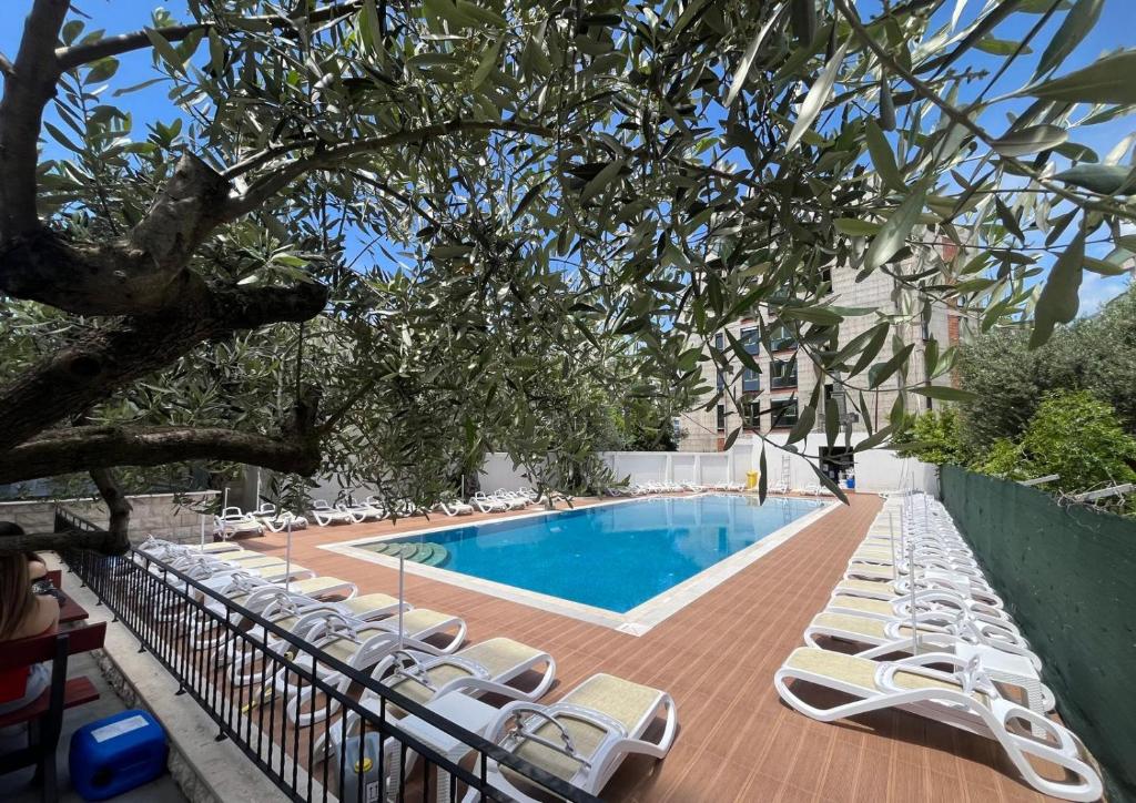 eine Gruppe von Liegestühlen und ein Swimmingpool in der Unterkunft Apartment ENJOY in Bar