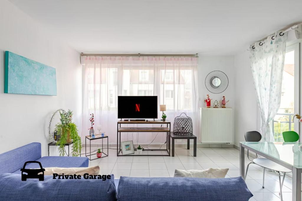 un salon avec un canapé bleu et une télévision dans l'établissement Quiet - Les Maraîchers - Terrace - Private garage, à Colmar