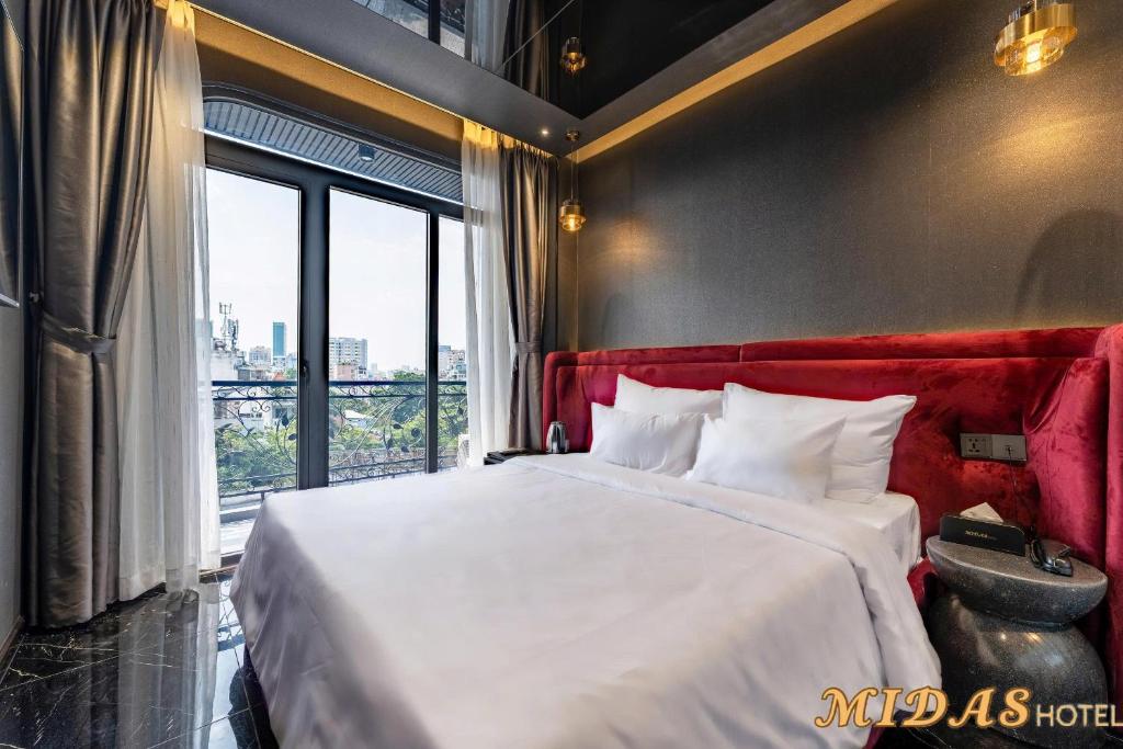 a bedroom with a bed and a large window at Midas Hotel 3 in Ho Chi Minh City