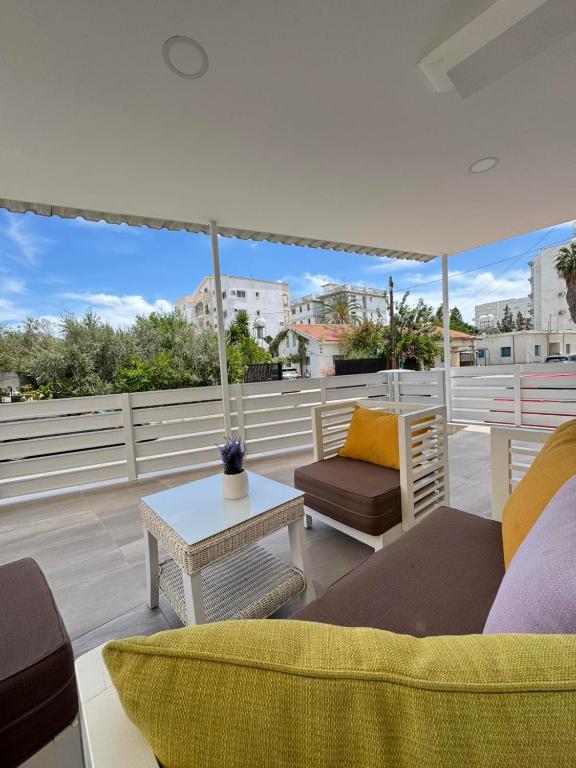 a living room with a couch and an umbrella on a roof at Makenzy Mermaid 2 Bedroom Apartment in Larnaca