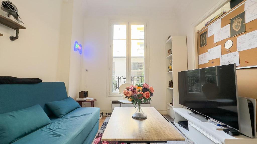 un salon avec un canapé bleu et une télévision dans l'établissement studio nice liberation, à Nice