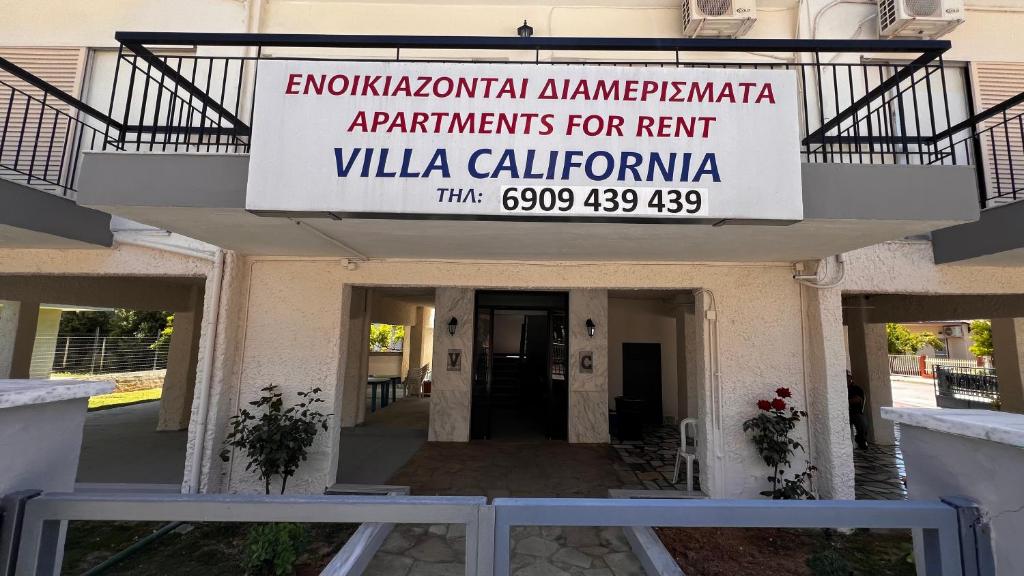 a sign for the entrance to a building at Villa California in Paralia Dionysiou