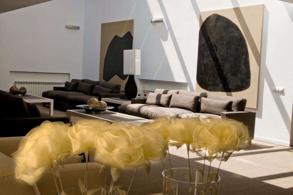 uma sala de estar com um sofá e uma mesa com flores em Hospedium Hotel Convento de Santa Ana em Atienza