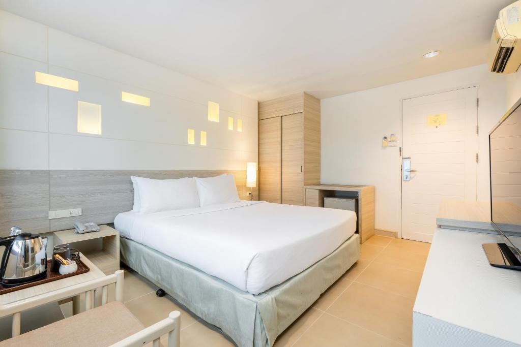 a bedroom with a large white bed in a room at Sunshine Hotel & Residences in Pattaya