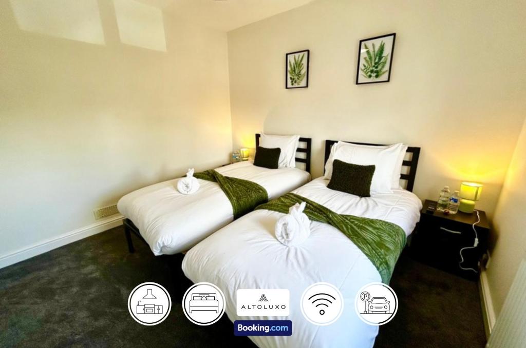 two twin beds in a room with three labels at The Jungle Comfy & Spacious 3BR by AltoLuxo Short Lets & Serviced Accommodation With Free WiFi & Parking in Bristol