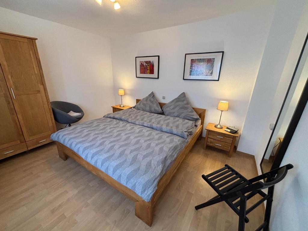 a bedroom with a bed and a chair and two lamps at Urlaub im Naturgarten in Bergneustadt
