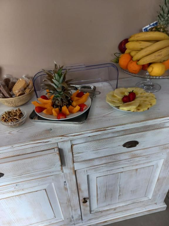 a table with plates of fruit on top of it at Hotel Villa Sveva in Cagliari