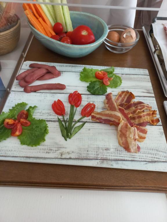a cutting board with meat and vegetables on a table at Hotel Villa Sveva in Cagliari