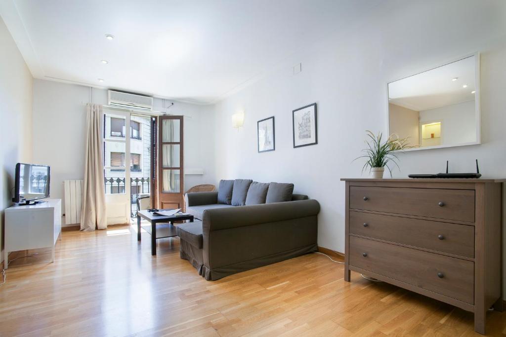 a living room with a couch and a dresser at BBarcelona Còrsega Flats in Barcelona