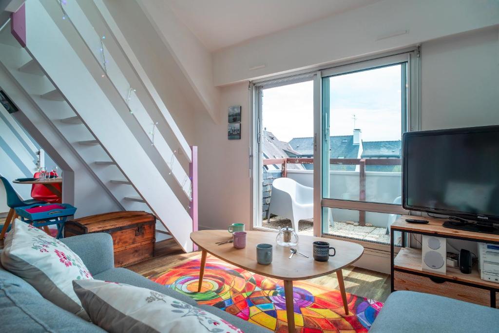 un salon avec un canapé, une télévision et une table dans l'établissement Holen Mor - Proche de la plage, à Carnac