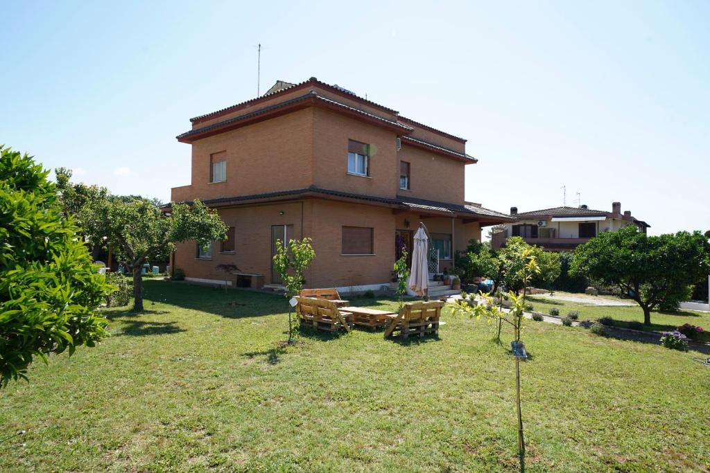 a house with a table and chairs in the yard at Da Piero e Gina in Palidoro
