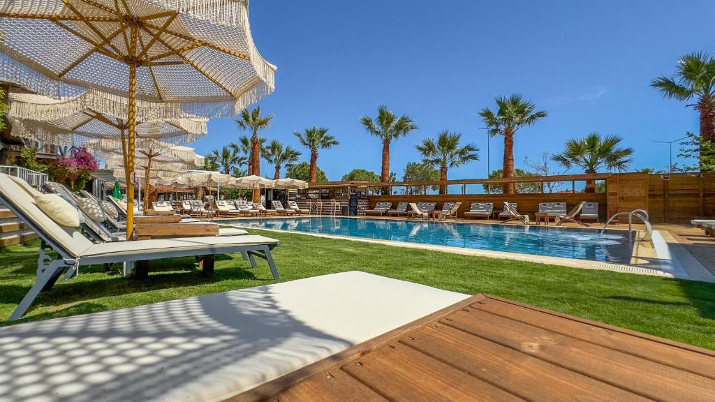 a pool with chairs and umbrellas in a resort at Gaia bungalow in Ayvalık