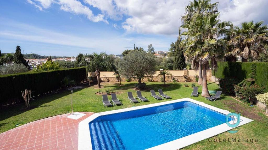 a swimming pool in the yard of a house at Villa Hole in One - GoLetMalaga in Mijas Costa