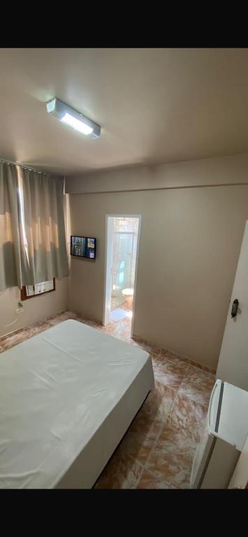 a bedroom with a large white bed in it at Hotel Gerais Business in Montes Claros