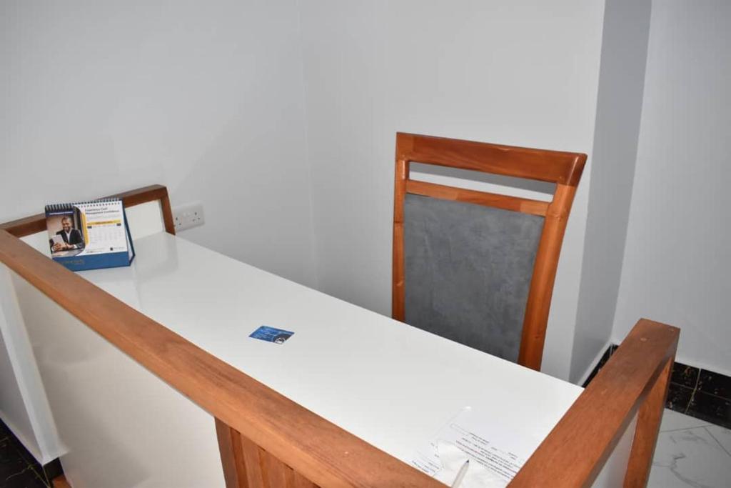a table and chairs with a white table and a chair at Volunteer House in Msaranga
