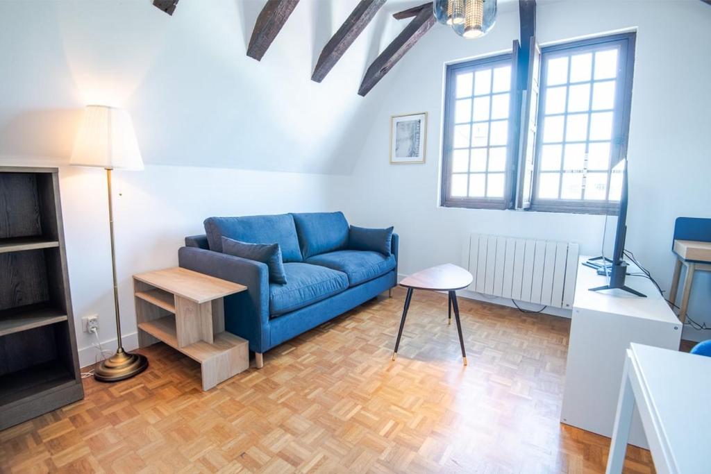 un salon avec un canapé bleu et une table dans l'établissement Le Donjon de Plumereau, à Tours