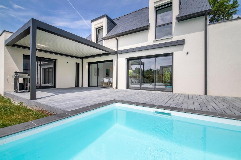 une maison avec une piscine devant une maison dans l'établissement Villa de la Grée, à Sarzeau