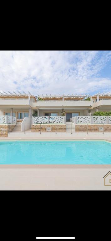 a large building with a swimming pool in front of it at Acqualife 3 luxury home in Arzachena