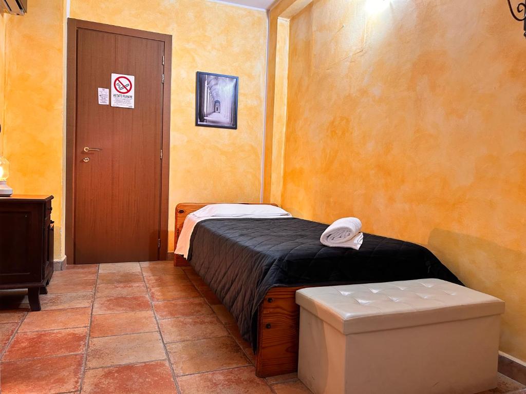a small room with a bed and a door at Locanda Dei Baroni in Vasto