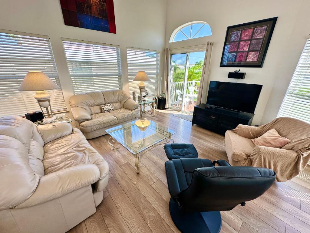 a living room with couches and a tv at Bluewater Haven in Jensen Beach