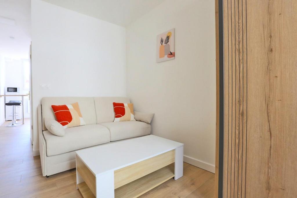 un salon avec un canapé blanc et une table dans l'établissement Le Cocon de Lobau - Calme et Tout confort - près CHU, à Nancy