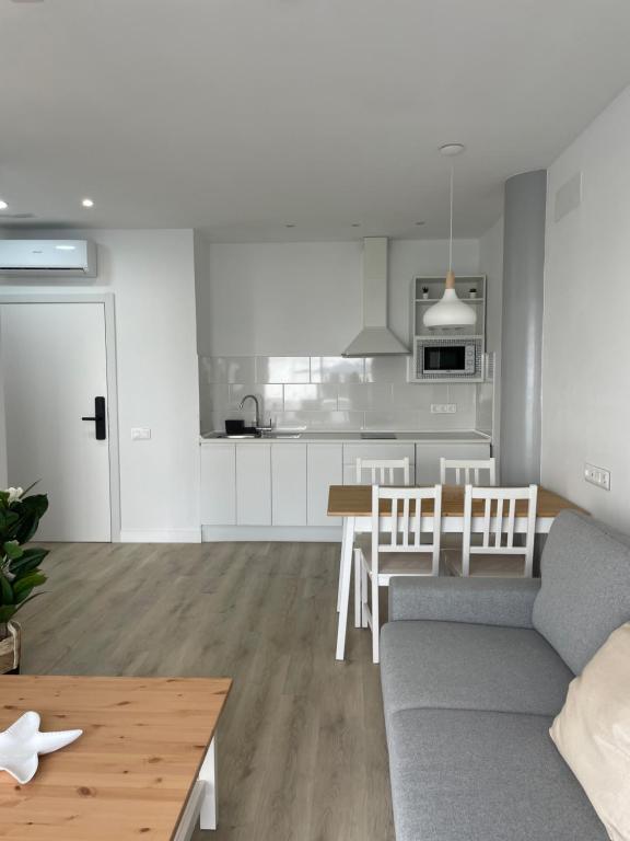 a living room and kitchen with a couch and a table at Island Home Fuerteventura in Corralejo