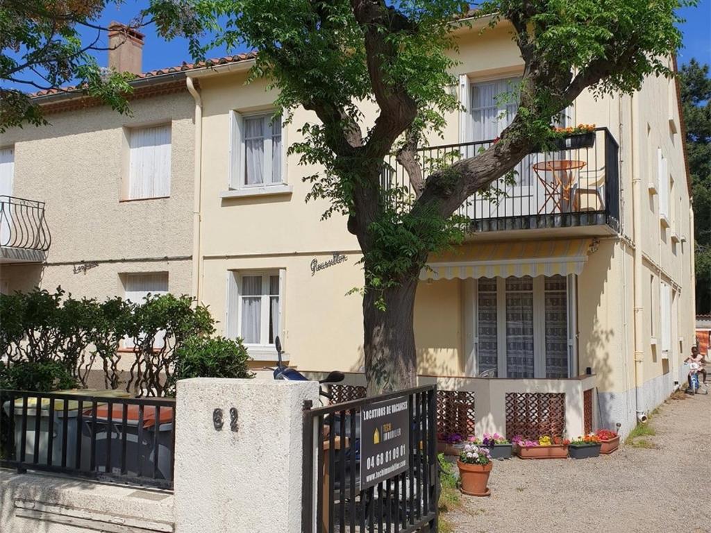 un bâtiment avec un arbre devant lui dans l'établissement Appartement T2 avec Parking à 200m de la Plage - FR-1-388-93, à Argelès-sur-Mer