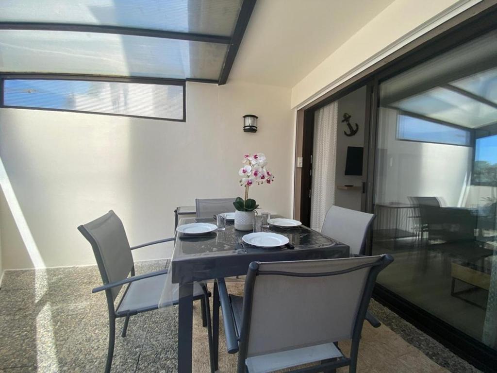 une salle à manger avec une table et des chaises noires dans l'établissement Appartement T2 avec véranda, sur le port de Capbreton, proche commodités, pouvant accueillir 4 pers. - FR-1-413-177, à Capbreton