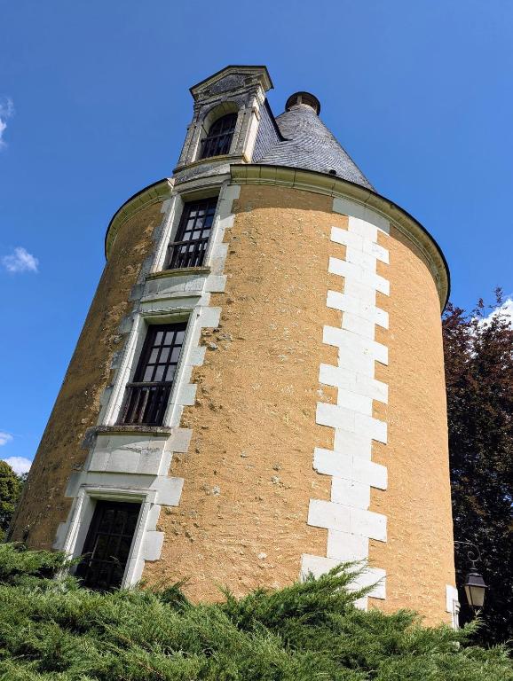 une grande tour en briques avec des fenêtres au-dessus de celle-ci dans l'établissement les portes de Chenonceaux, à La Celle-sous-Gouzon