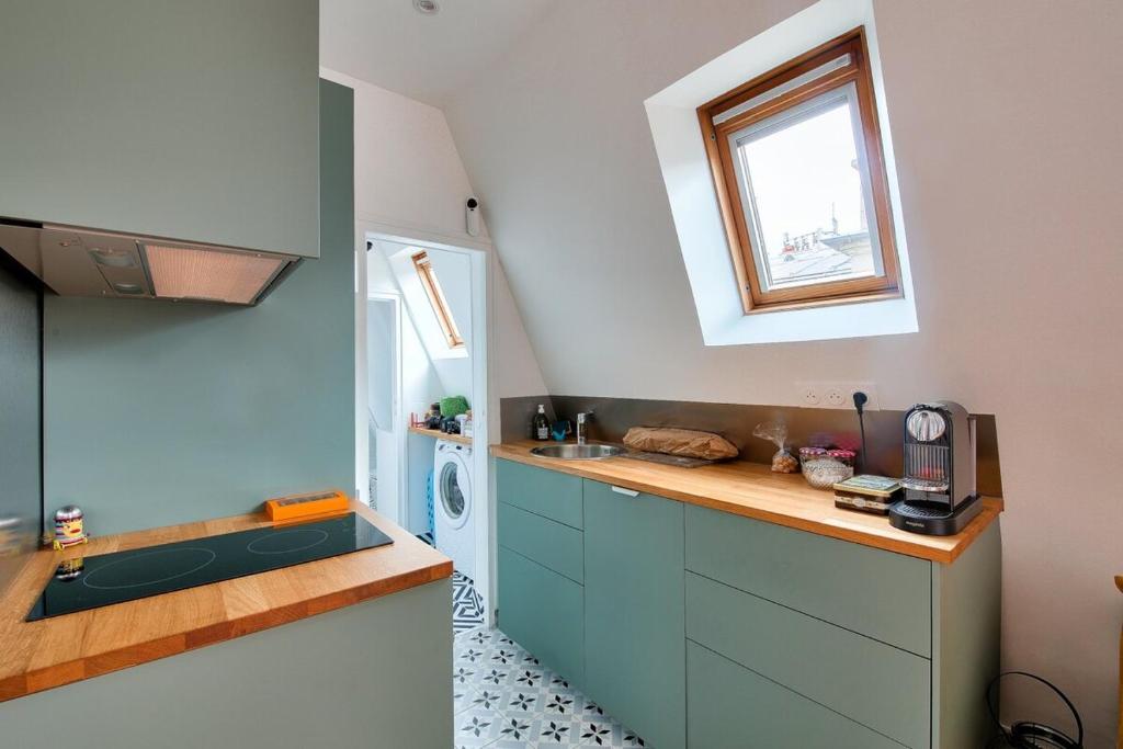 une petite cuisine avec un évier et une fenêtre dans l'établissement Cosy appart cœur de Paris 2 pers, à Paris