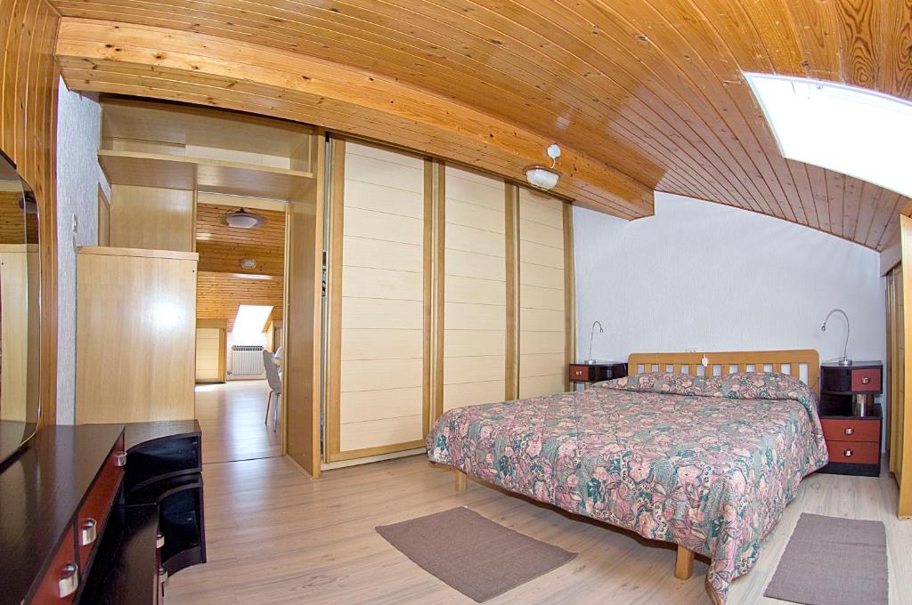 sypialnia z łóżkiem i drewnianym sufitem w obiekcie Apartments Tomato w mieście Novigrad