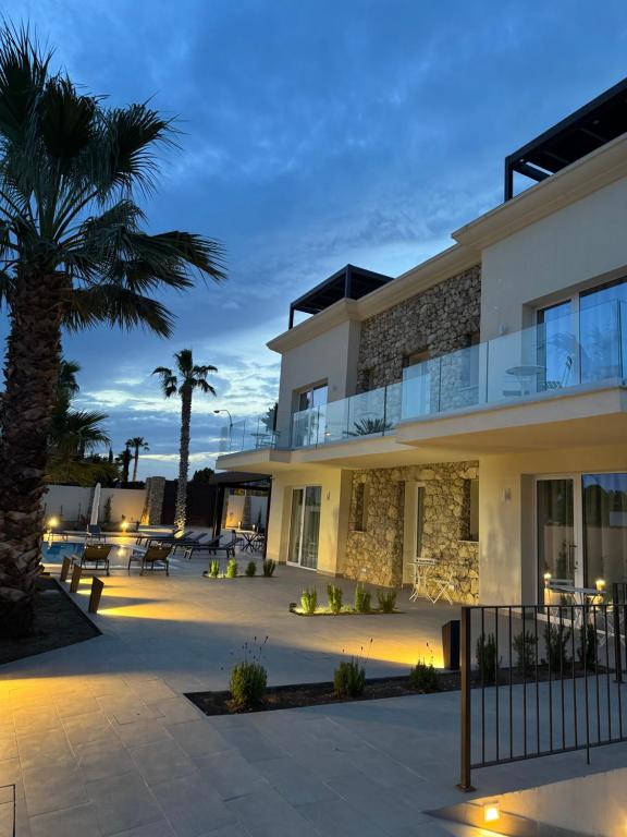 a building with a palm tree in front of it at Limonaia Luxury Villa in Porto Empedocle
