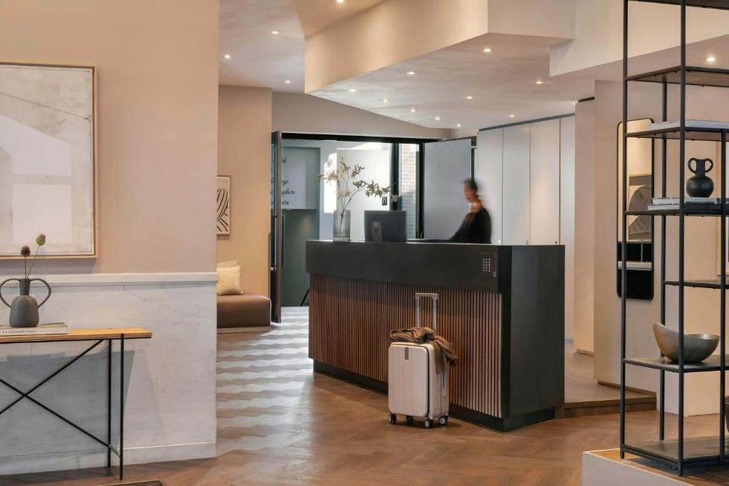 a woman standing at the counter of a store at Park House Hotel Museum Quarter, Sonder by Marriott Bonvoy in Amsterdam