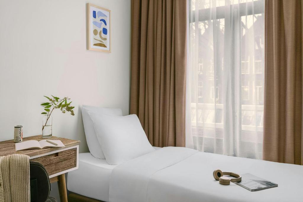 a hotel room with a white bed and a window at Park House Hotel Museum Quarter, Sonder by Marriott Bonvoy in Amsterdam