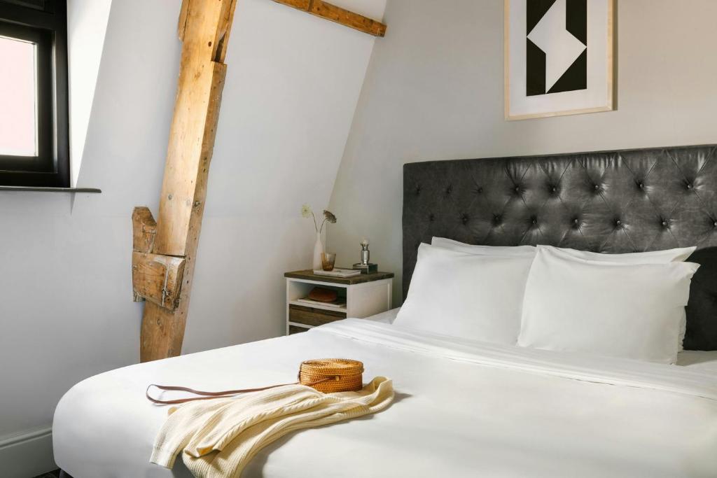 a bedroom with a white bed with a black headboard at Park House Hotel Museum Quarter, Sonder by Marriott Bonvoy in Amsterdam