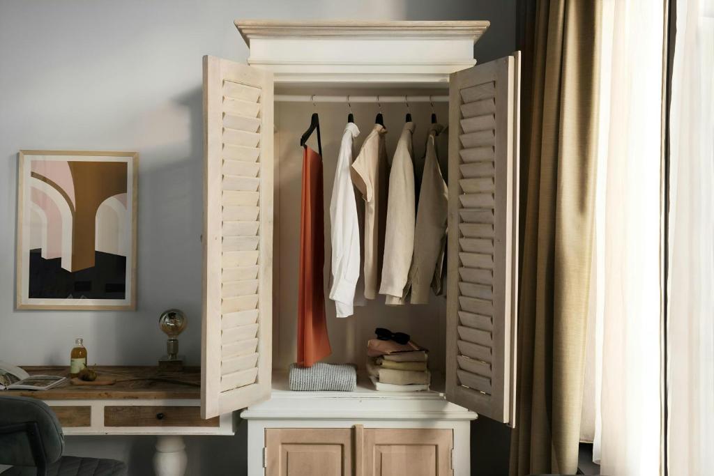 a wooden wardrobe in a room with clothes at Park House Hotel Museum Quarter, Sonder by Marriott Bonvoy in Amsterdam