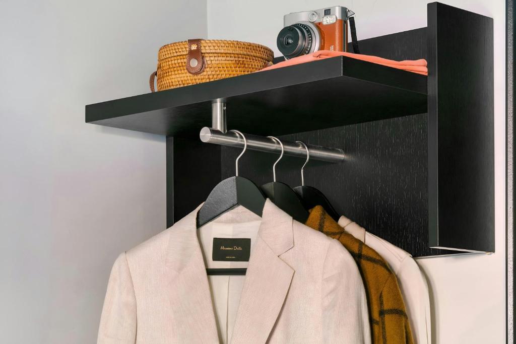 a shelf with a white jacket and a camera on it at Park House Hotel Museum Quarter, Sonder by Marriott Bonvoy in Amsterdam