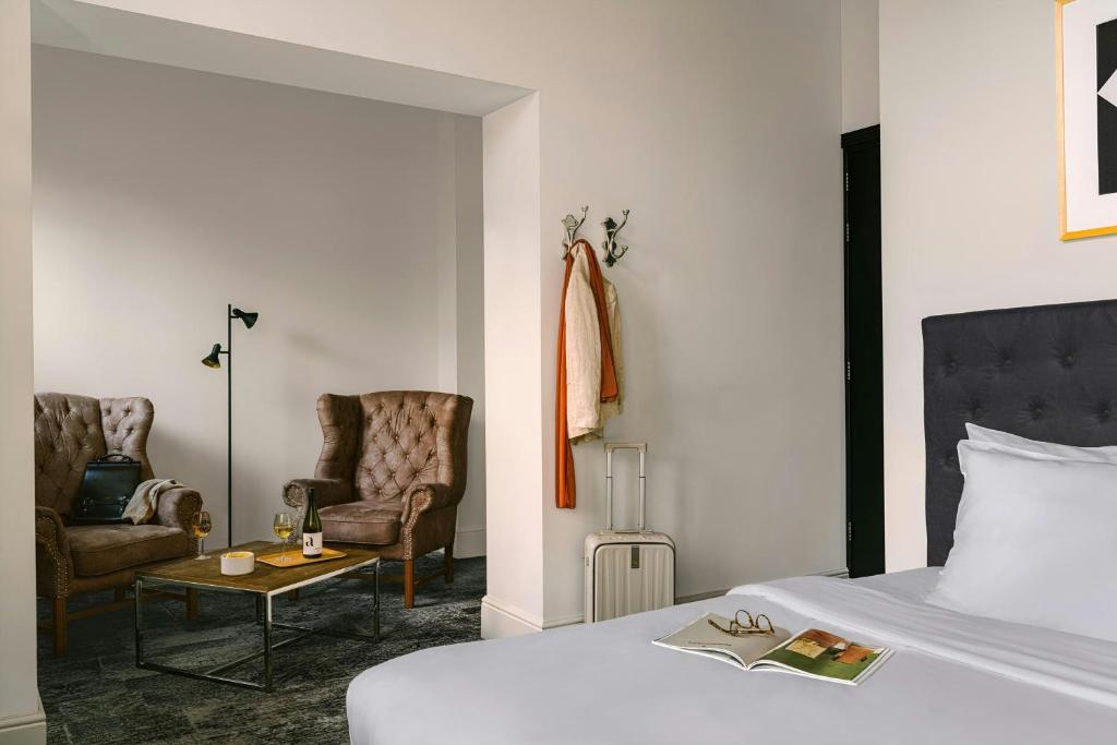 a bedroom with a bed and two chairs and a table at Park House Hotel Museum Quarter, Sonder by Marriott Bonvoy in Amsterdam