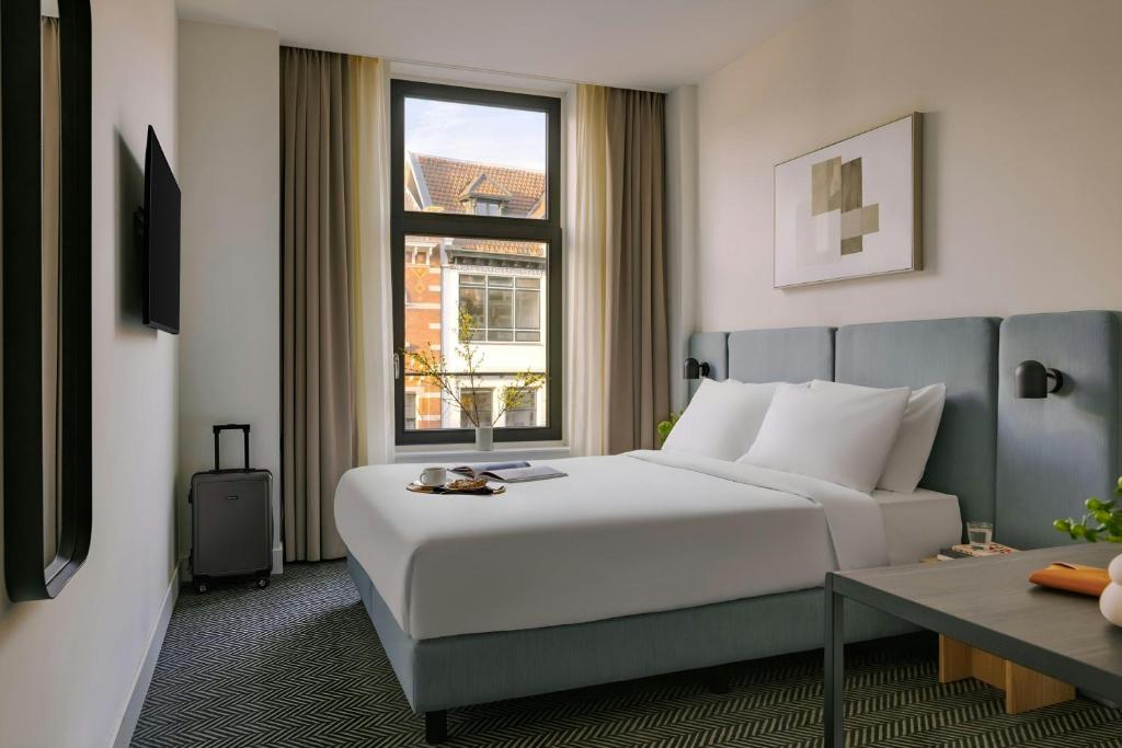a hotel room with a bed and a window at Hotel Rose Rotterdam in Rotterdam