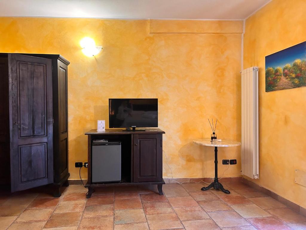 a room with a tv and a table and a door at Locanda Dei Baroni in Vasto