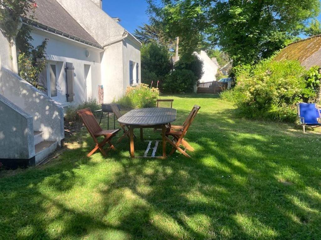 - une table et des chaises dans la cour d'une maison dans l'établissement Longère rénovée proche Palais avec jardin, 5 chambres, 3 salles de bain, WIFI, idéale famille - FR-1-418-179, au Palais