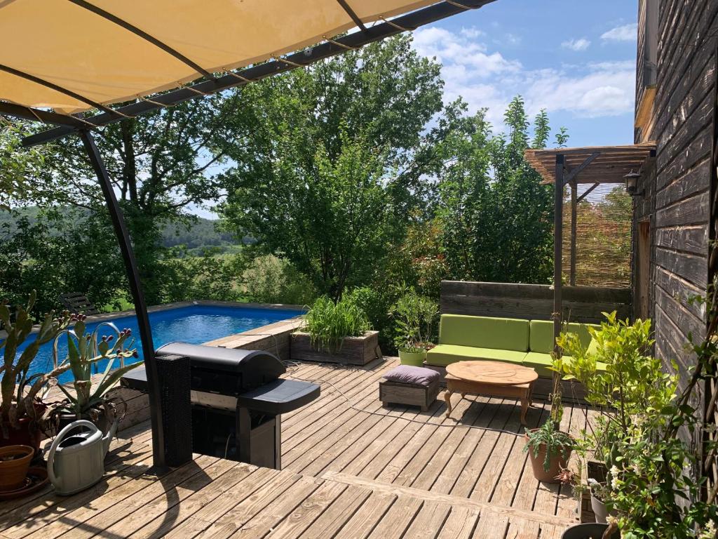 un patio avec un banc vert et une piscine dans l'établissement Jolie maison en bois avec piscine, à Saint-Césaire-de-Gauzignan