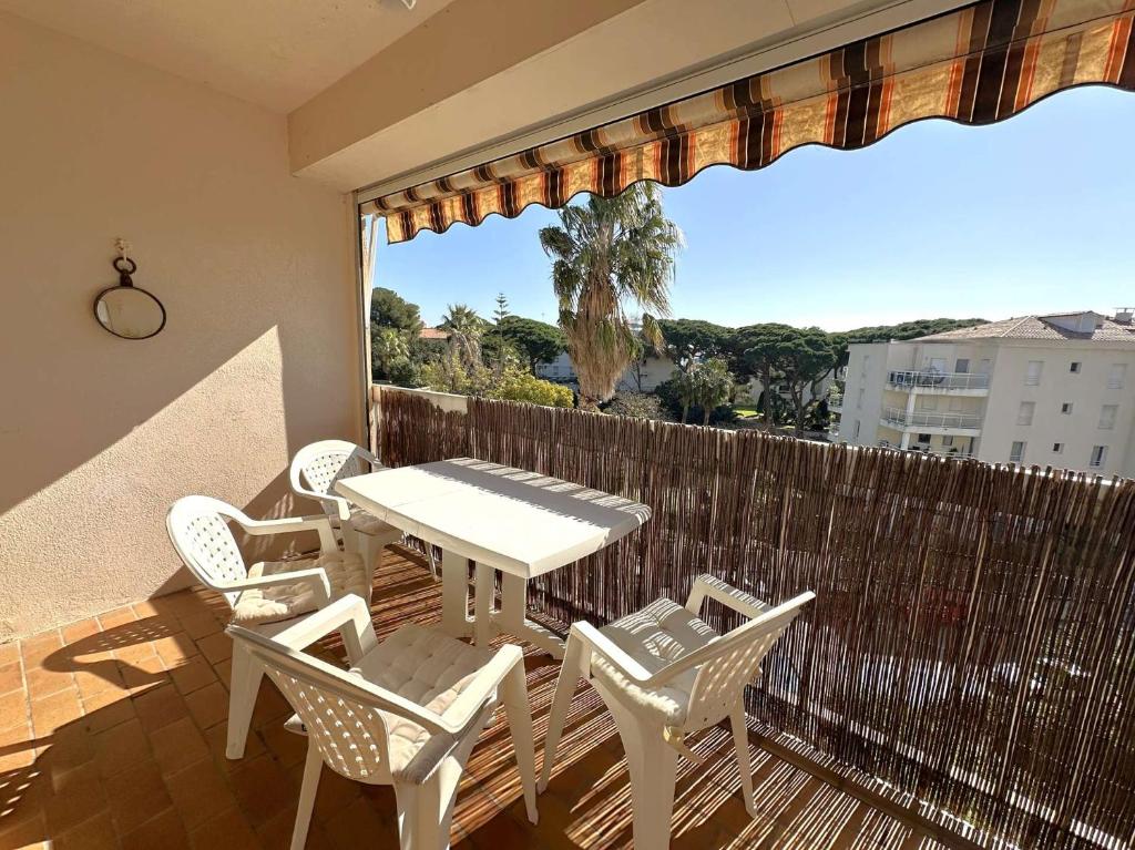 un patio avec une table et des chaises sur un balcon dans l'établissement HYEPHI T2 pour 4 personnes dans résidence avec piscine - Hyères Port, à Hyères