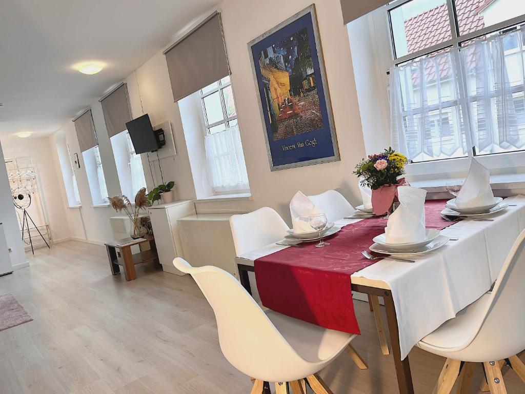 una sala da pranzo con un tavolo e sedie bianche di Loftartiges Appartment in Magdeburg, 2 Schlafzimmer, Küche und Bad - B a Magdeburgo