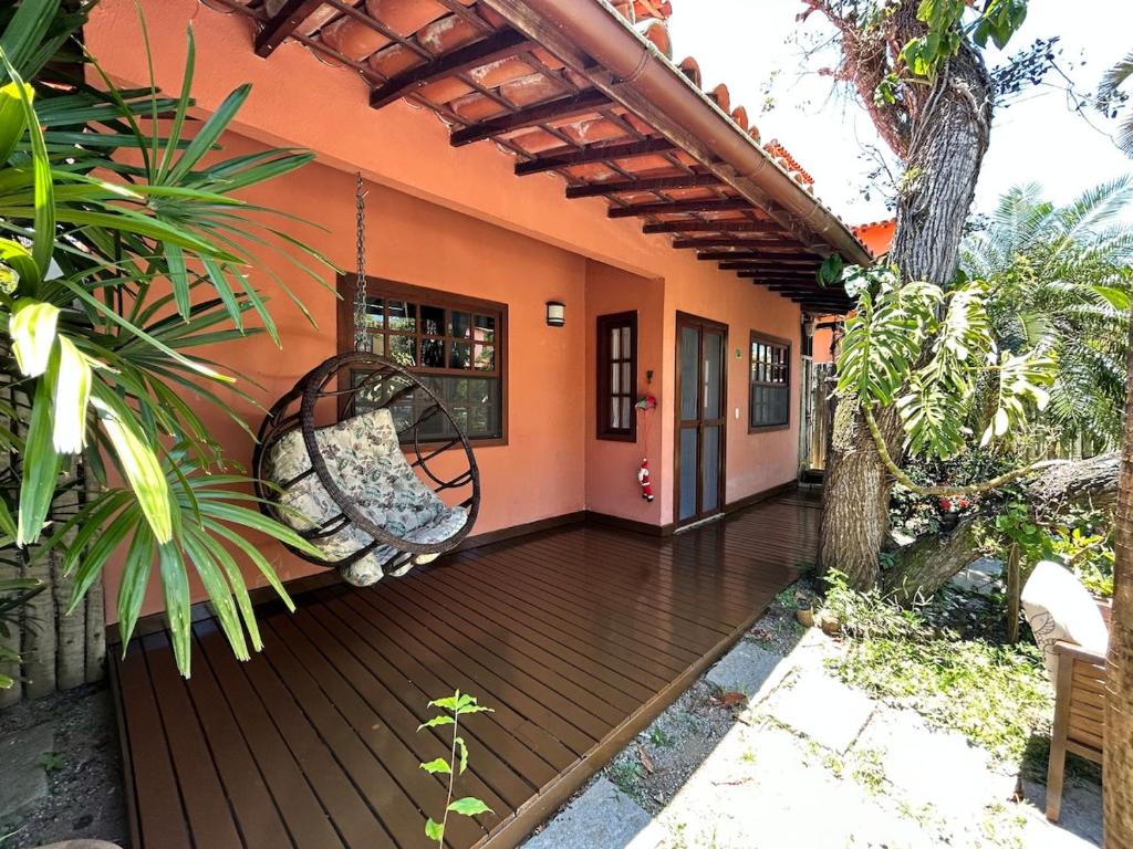 a porch of a house with a swing at Casa Quinta do Atlântico - Aconchego da Paz 150m da praia in Búzios