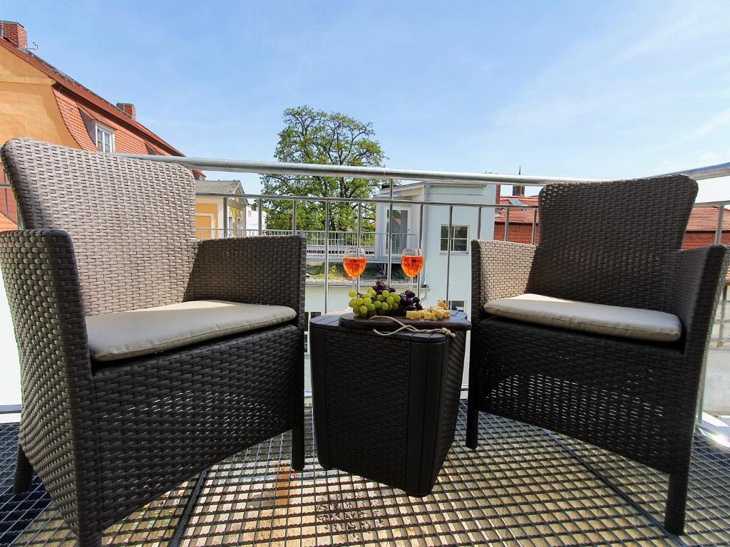 dwa krzesła i stół na patio w obiekcie Hogulu - 2 - RAUM - App 13 mit Balkon im Herzen der Altstadt w mieście Brandenburg an der Havel
