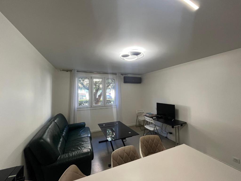 un salon avec un canapé en cuir noir et une table dans l'établissement Port Lympia - Grand 2 Pièces Confort, à Nice