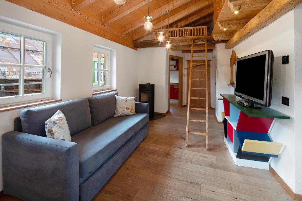 カンピテッロ・ディ・ファッサにあるDolomites Chalet Pianのソファとテレビのあるリビングルーム